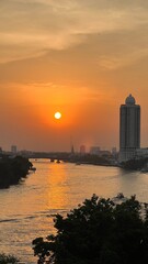 Fototapeta premium Aerial view of boat traffic on Chao Praya river with sunset, skyscrapers along Chao Praya river during sunset.