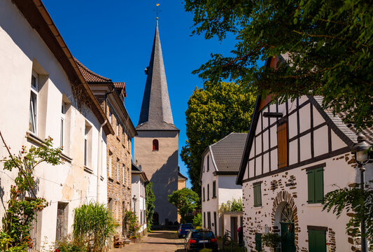 Neuenrade is a small city in Sauerland, Germany. Idyllic view into picturesque &ldquo;Eulengasse&ldquo; an old town road with typical half timbered houses and protestant church tower on a sunny summer day.