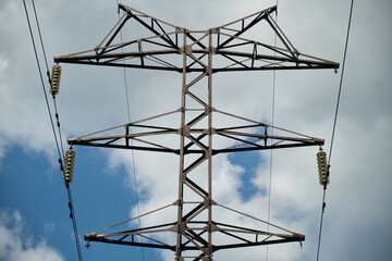 High-voltage power line, electricity pylon, power line mast against the blue sky, wires and glass...