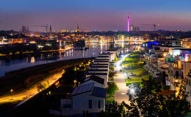 Night panorama of Dortmund Germany. Former blast furnace site and new recreational area in Hoerde called “Phoenixsee“. TV-Tower and skyline in the background after colorful sunset in springtime. 