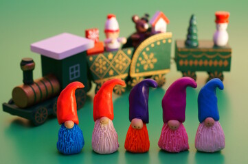 Figures of dwarfs and a Christmas train on a green background. Christmas toys.