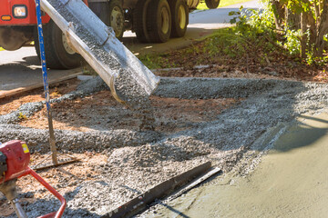 Mixer truck pouring wet cement ready mixed concrete for driveway near home