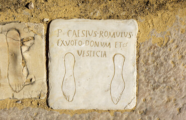Votive plaques on the floor of the Porta Triumphalis, one of the access gates to the Italica Amphitheater. Roman city of Italica, located in Santiponce, Seville, Andalusia, Spain.