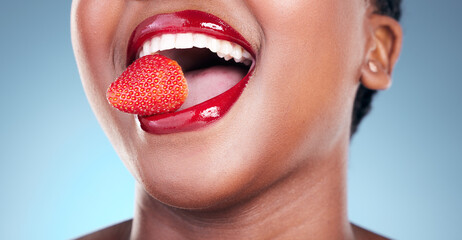 Woman, eating and strawberry, red lipstick and beauty, makeup closeup isolated on blue background....