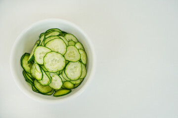 白い器に盛られた薄く輪切りにスライスされたキュウリ