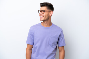 Fototapeta premium Young caucasian man isolated on white background looking to the side and smiling