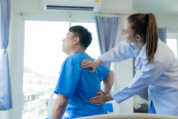 Female doctor doing physiotherapy stretching male patient's shoulder, doctor doing osteoporosis treatment exercise in modern clinic.