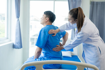 Obraz premium Female doctor doing physiotherapy stretching male patient's shoulder, doctor doing osteoporosis treatment exercise in modern clinic.