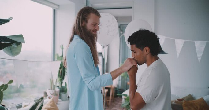 Young queer couple holding hands and kissing. 