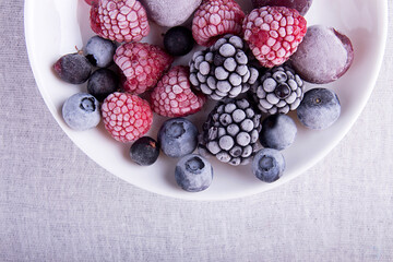 Frozen raspberries, blackberries, blueberries, blueberries, cherries, black currants on a white plate