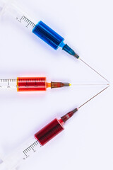 Medical Syringes with needles isolated on white. Macro shooting. Syringes filled with colored medication liquids.