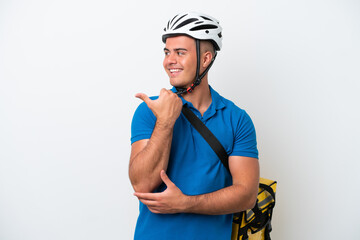 Young caucasian man with thermal backpack isolated on white background pointing to the side to present a product