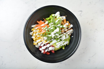 colourful healthy bowl assorted salad, vegetables, avocado, corn, bean, carrot rainbow salad dressing sauce on white marble table background chef cook healthy poke bowl halal vegan food menu