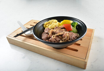 stir fried bbq bulgogi beef rice bowl with scrambled eggs and fried vegetable salad in black bowl on white marble table background chef cook healthy poke protein bowl halal vegan food menu