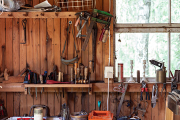 Messy wooden workshop table with many tools