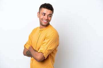 Young caucasian Brazilian man isolated on white background looking to the side and smiling