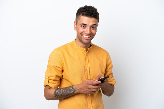 Young Caucasian Brazilian Man Isolated On White Background Sending A Message With The Mobile