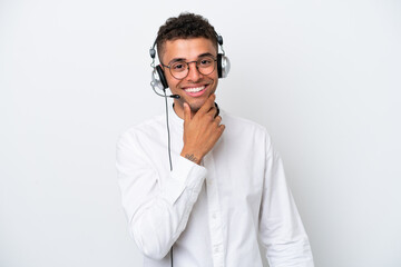 Telemarketer Brazilian man working with a headset isolated on white background with glasses and smiling