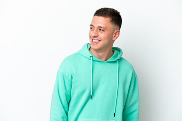 Young brazilian man isolated on white background looking to the side and smiling