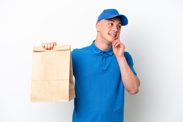 Young Brazilian man taking a bag of takeaway food isolated on white background thinking an idea while looking up