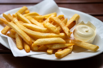 Eating of street or take away food fresh baked french fried potatoes chips with Belgian mayonnaise