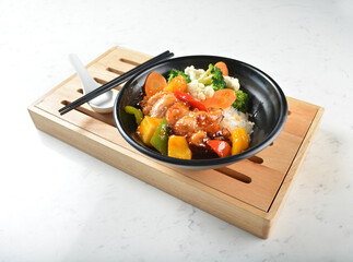 hawaiian sweet and sour grilled chicken pineapple rice bowl with fried vegetable salad in black bowl on white marble table background chef cook healthy poke bowl halal protein food menu