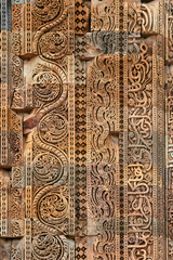 Wall decorative patterns of Qutb complex in South Delhi, India, close up ancient bas relief wall decorations of mosque ruins landmark, popular touristic spot in New Delhi, ancient indian architecture