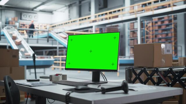Empty Workplace Of Sorting Center Employee With Green Screen Chromakey Desktop Computer Monitor And Barcode Reader. Conveyor Belt With Online Orders Packaged In Cardboard Boxes Working On Background.
