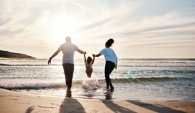 Mom, Dad And Swing Girl On Beach, Holiday And Vacation In Florida For Bonding, Adventure And Family Together In Waves. Mother, Father And Child At Sunset In Ocean, Sea Or Playing In Water For Fun