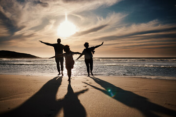 Family, running and silhouette on beach with sunset, freedom and fun together, games and bonding on...