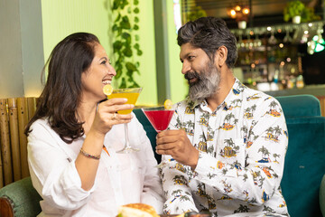 Indian Couple enjoying food and drink at restaurant