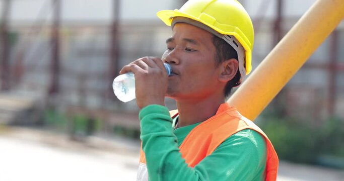 Construction worker man people drinking water from water bottles. Take a break from hard work. Tired hot wiping sweat