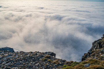 Rocky cliff and wonderful view of the clouds below
