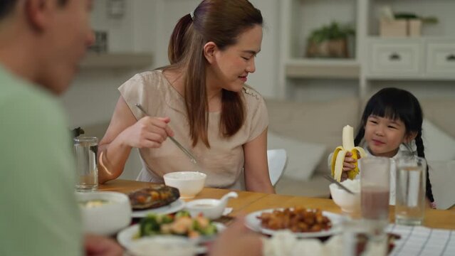 Asian Happy Family Spend Time Have Breakfast Or Dinner On Table Together At Sunlight.Little Kid Daughter Enjoy Eat Yummy Food With Father,asian Mother.asia Family Day Meet Talk At Home