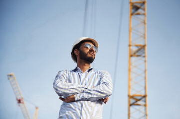 Naklejka na ściany i meble Manager in sunglasses. Handsome Indian man is on the construction site