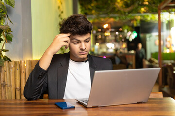 Young indian boy using laptop at restaurant © PRASANNAPIX