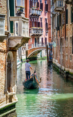 Traditional gondola ride on the narrow water canals.Tourists in Venice. © Cristi