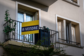 'A vendre' écrit en Français sur une enseigne jaune fixée à l'extérieur d'un appartement dans...