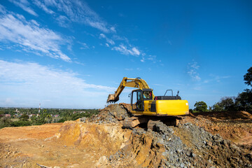An excavator machine digging soil at a construction project site, showcasing heavy machinery in...