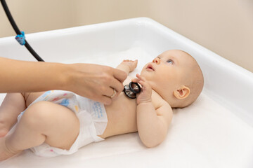 Medical check up. Pediatrician listening to baby's lungs and heart, close up