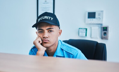 Portrait, surveillance and a bored man security guard sitting at a desk in his office to serve and...