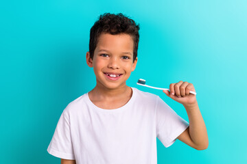 Portrait of charming cheerful small boy toothy smile hand hold toothbrush isolated on turquoise color background