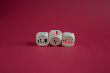 Turned wooden cube and changes the concept word Your choice to voice. Beautiful maroon background, copy space. Business and your voice choice concept