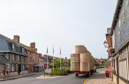 06-07-2023 -historical half-timbered houses in Beuvron-en-Auge, France Normandy Tractor filled with bales of straw : entering Beuvron en Auge