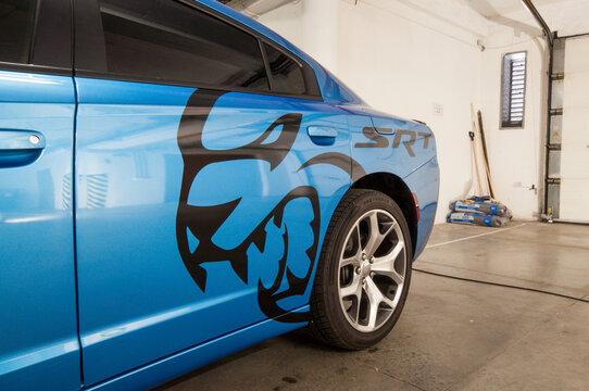 Brno, Czech Republic - 18 May 2021: A blue luxury fast car with a black foil sticker is parked in a garage.