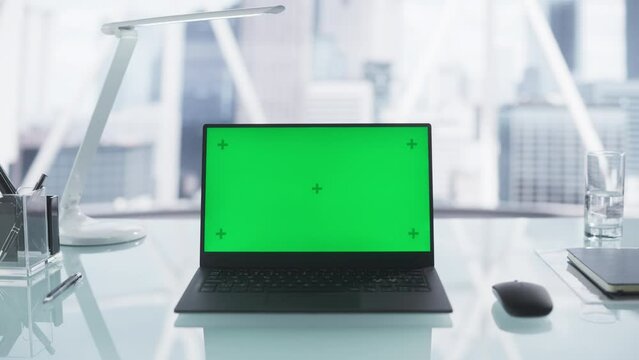 Laptop Computer with Mock Up Green Screen Chromakey Display with Motion Trackers Standing on an Office Desk in a Modern Company Headquarters. Template Video for Promotional Business Materials