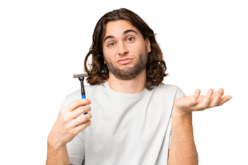 Young handsome man shaving his beard over isolated background making doubts gesture while lifting the shoulders