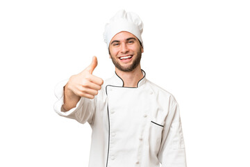 Young handsome chef man over isolated background with thumbs up because something good has happened