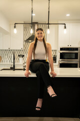 young woman realtor sitting on a kitchen counter