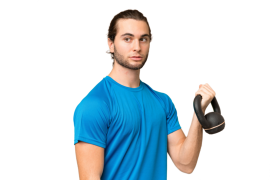 Young handsome man isolated on green chroma background making weightlifting with kettlebell